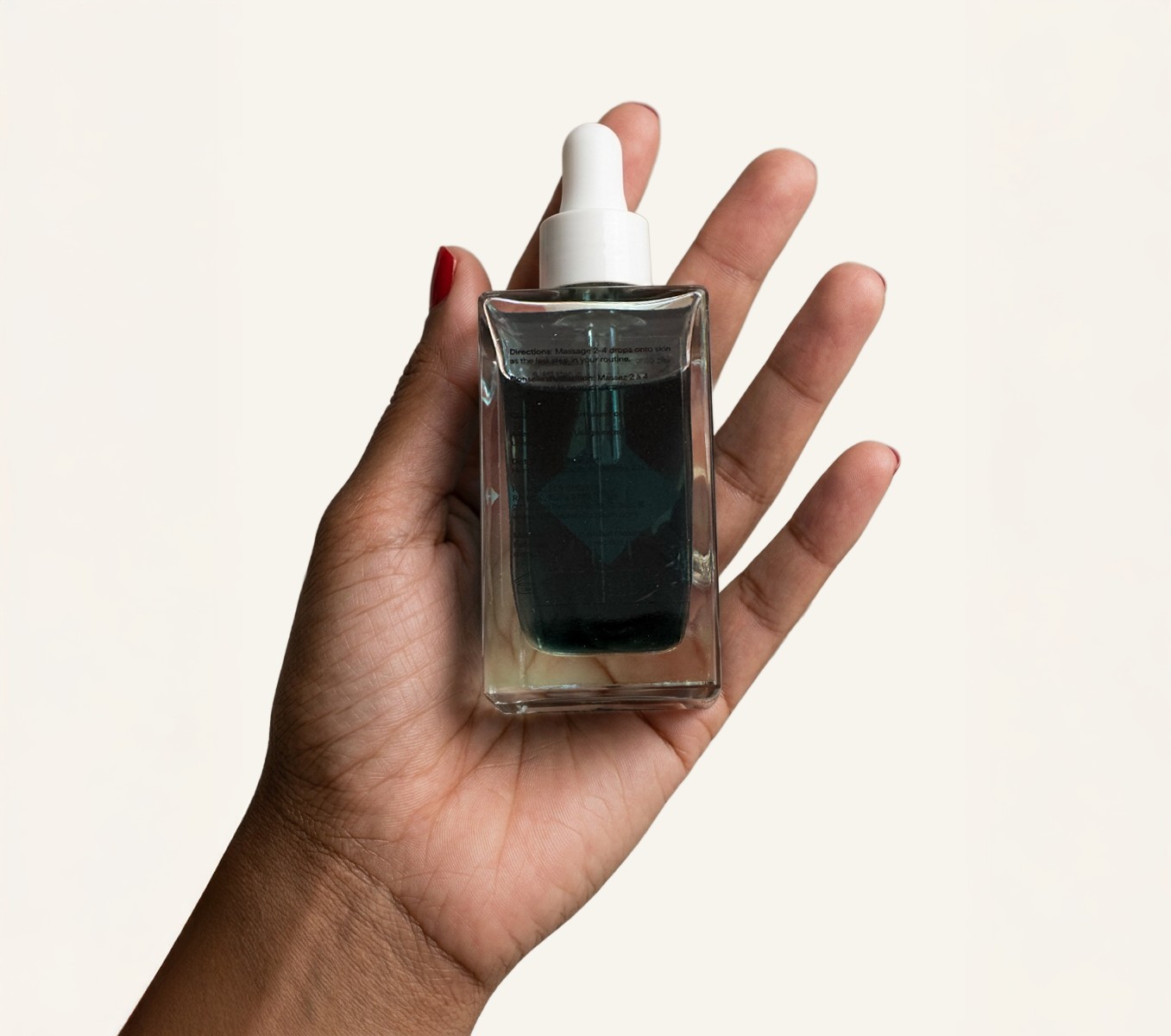 Hand holding the Lapis bottle showing the hard-to-read transparent back label