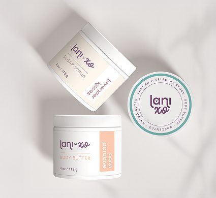 Lani.xo body care packaging arranged on draped fabric