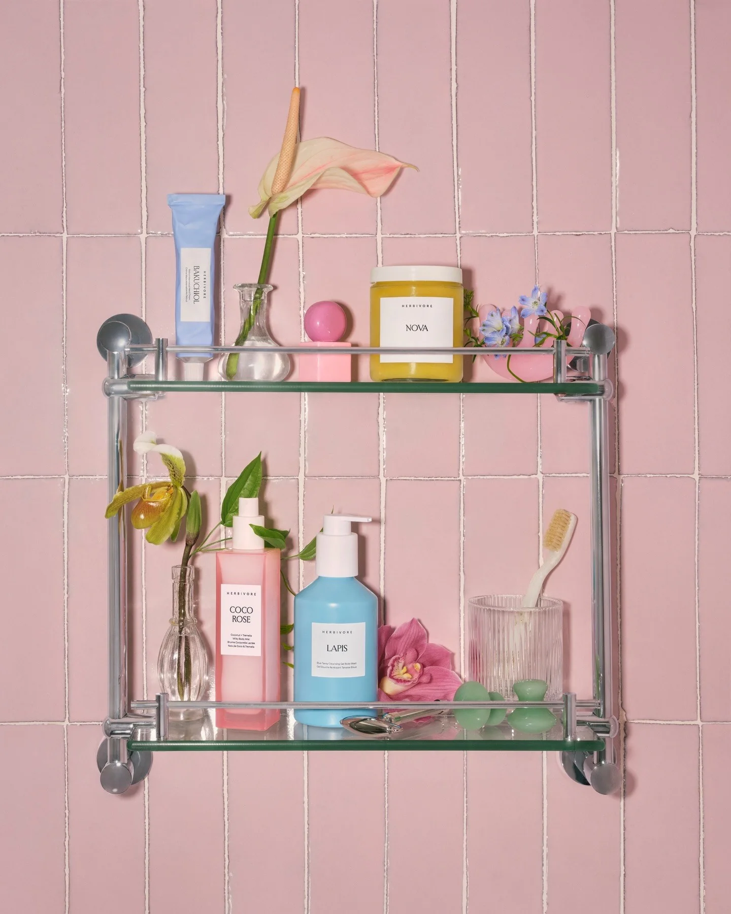 Herbivore products styled on a pink tiled bathroom shelf